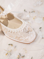 Top-down view of pearl toe cap detail on champagne flats